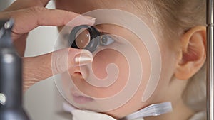 Child in ophthalmology clinic - optometrist diagnosis little blonde girl