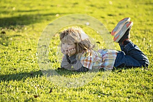 Child outdoor in park. Spring kid lying on grass. Summer boy walk. Children adaptation.