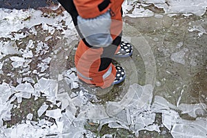 A child in overalls walks on thin ice