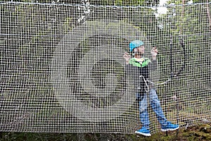 Child overcoming mesh obstacle in rope adventure park
