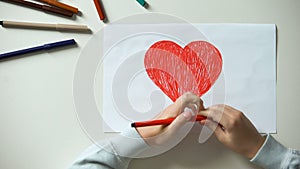 Child painting big red heart, Saint Valentines Day gift, first love, childhood