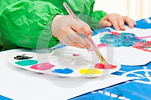 Child painting with brush