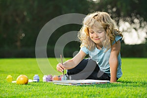 Child painting drawing art. Schooler kids drawing in summer park, painting art. Little painter draw pictures outdoor.