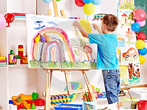 Child painting at easel.