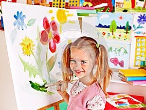 Child painting at easel.