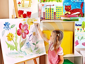 Child painting at easel.