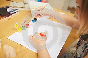 Child Painting. Happy preschool age girl holding a brush painting with paint. Do it yourself project with kids at home