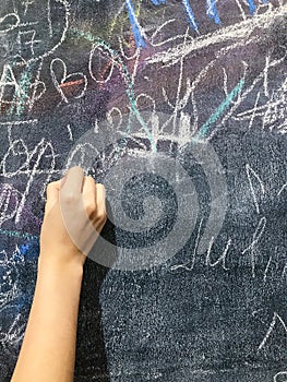 A child paints by chalk on a school board