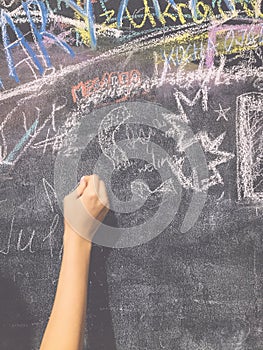 A child paints by chalk on a school board