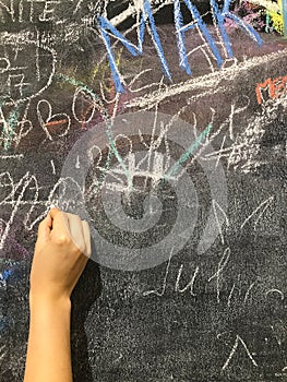 A child paints by chalk on a school board