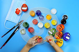 Child paints Easter eggs with colors, coronavirus theme