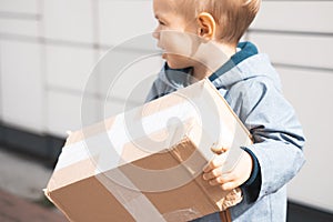 Child parcel, boy using self service parcel terminal machine to send or receive package. Parcel delivery, pickup point
