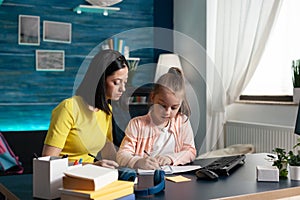 Child and parent doing homework together at home