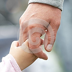 Child and parent holding hands photo