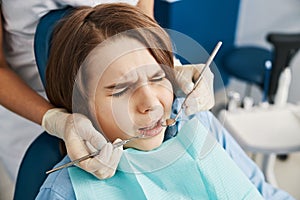 Child patient squinting with fear of dental instruments