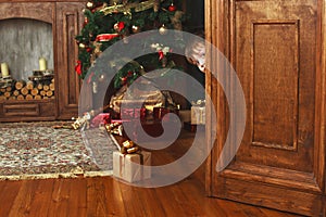 Child peeking from behind the door of the gift