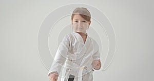 The child performs a special exercise for karate. A diligent athlete performs various exercises.