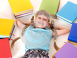 Child with pile of book lying on floor.