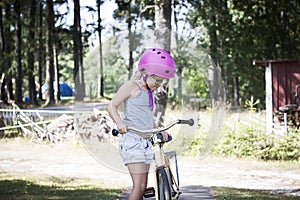 Child with pink bicycle helmet learning to bike