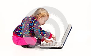 Child in pink typing on laptop, isolated