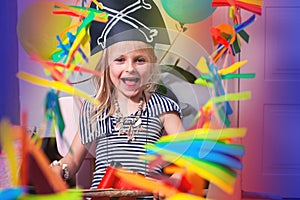 A child in a pirate costume smiles and plays. Bright festive photo of a pirate party. Baby`s birthday. Adventure and travel at