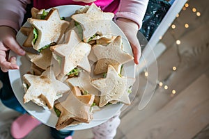 child with a plate of starshaped sandwiches