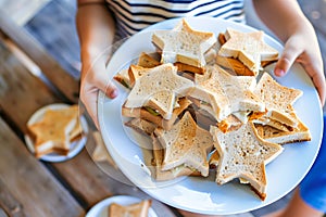 child with a plate of starshaped sandwiches