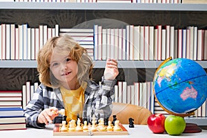 Child play chess in classroom at school. Kid thinking about chess. The concept of learning and growing children. Chess