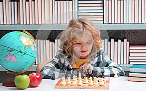 Child Play chess. Clever concentrated and thinking kid playing chess. Kids brain development and logic game.