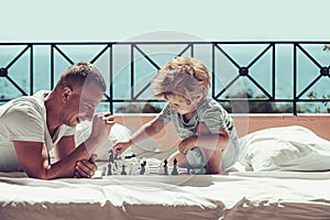 Child play chess with father. Summer vacation of happy family. Family travel with kid on fathers day. father with son on