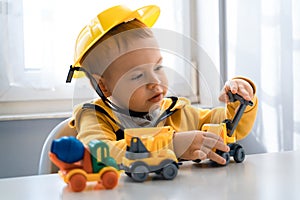 Child play with construction machinery at home, dreams to be an engineer. Little builder. Education, and imagination