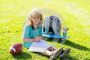Child play and draw craft artwork homework. School boy in park outdoor doing school homework. Child kid writing in