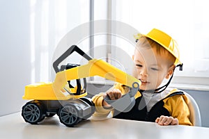 Child play with excavator at home, dreams to be an engineer. Little builder. Education, and imagination, purposefulness