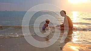 Child Play with Mom on the Beach at Sunset