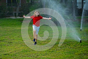 Child play near automatic sprayers in the garden. Watering in the garden. Kid freshness of nature. Automatic lawn
