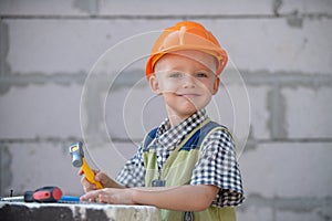 Child play with supplies, tools saw, hammer, screwdriver, helmet, builder, carpenter. Kids playing in the profession