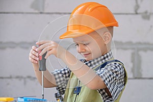 Child play with supplies, tools saw, hammer, screwdriver, helmet, builder, carpenter. Kids playing in the profession