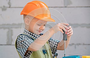 Child play with supplies, tools saw, hammer, screwdriver, helmet, builder, carpenter. Kids playing in the profession