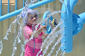 Child play with water fountain in water park