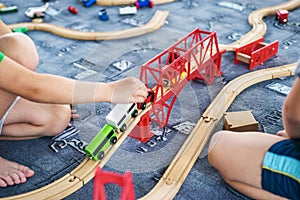 Child play with wooden train, build toy railroad at home or kindergarten. Toddler kid play with wooden train