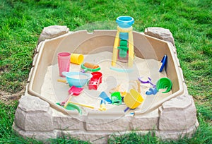 Child playground with Sandbox and toys in a backyard