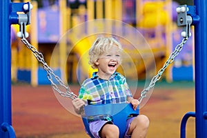 Child on playground. swing Kids play outdoor