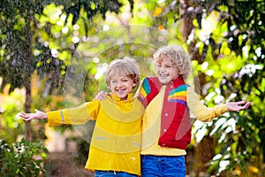 Child playing in autumn rain. Kid with umbrella