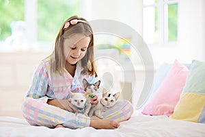 Child playing with baby cat. Kid and kitten