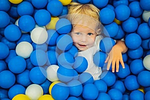 Child playing in ball pit. Colorful toys for kids. Kindergarten or preschool play room. Toddler kid at day care indoor