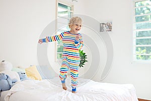 Child playing in bed. Kids room. Baby boy at home