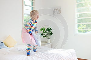 Child playing in bed. Kids room. Baby boy at home