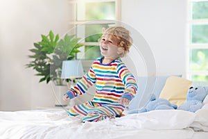 Child playing in bed. Kids room. Baby boy at home