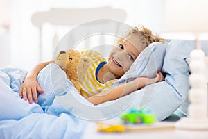 Child playing in bed. Kids room. Baby boy at home