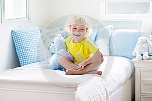 Child playing in bed. Kids room. Baby boy at home